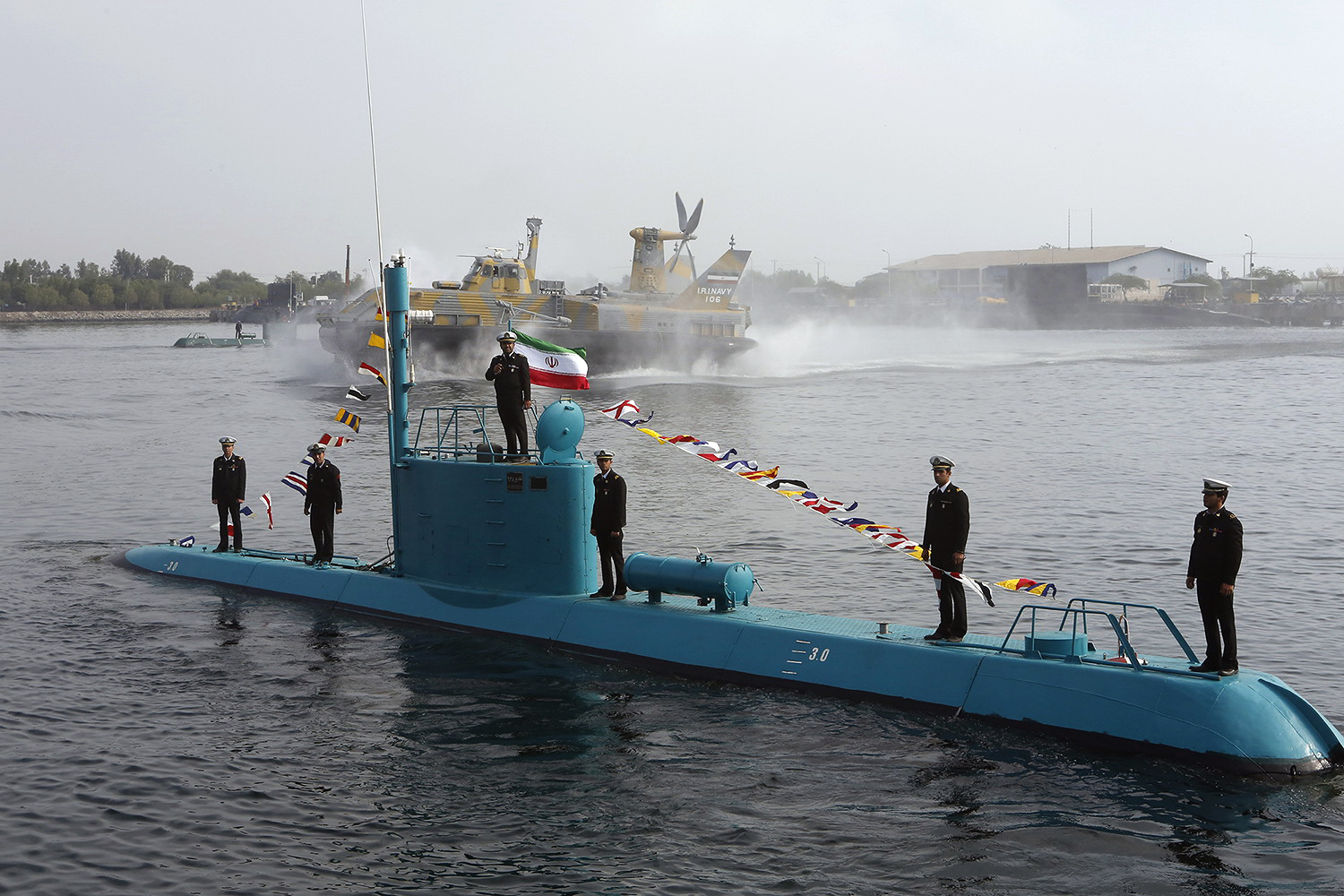 An Iranian Qadir light submarine and a hovercraft move in the Gulf waters in southern port of Bandar Abbas on November 28, 2012, after they were launched in an official ceremony. Iran boosted its naval power in Gulf waters after a new missile launching vessel and two light submarines joined its Navy fleet. AFP PHOTO/MEHR NEWS/AHMAD JAFARI